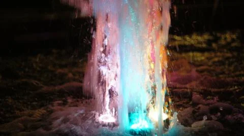 The fountain, lit by multicolored lights. Stock Photos