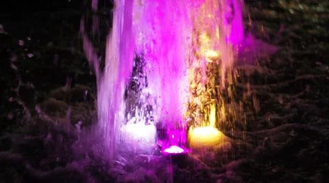 The fountain, lit by multicolored lights. Stock Photos
