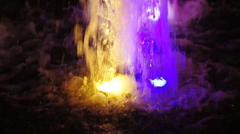 The fountain, lit by multicolored lights. Stock Photos