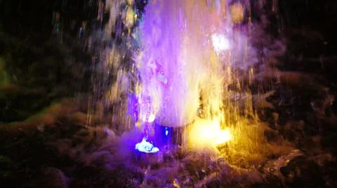 The fountain, lit by multicolored lights. Stock Photos