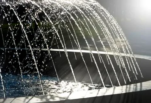 Fountain, lit setting sun. Stock Photos