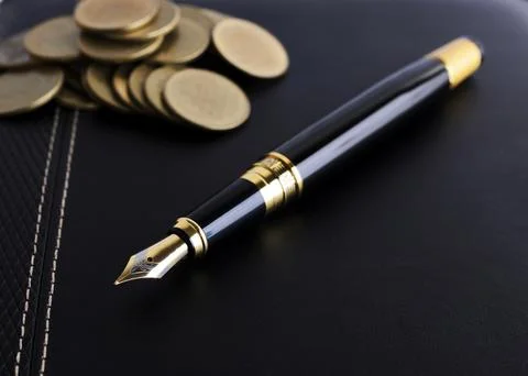 Fountain pen and coins stack on leather book for business finance concept Stock Photos