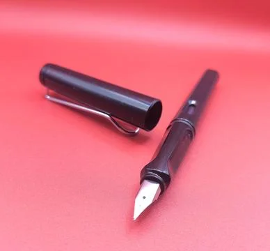 Fountain pen on red surface Stock Photos