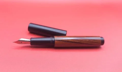 Fountain pen on red surface Stock Photos