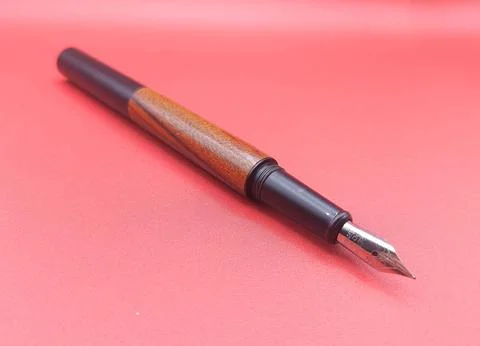 Fountain pen on red surface Stock Photos