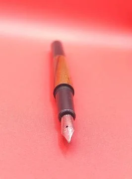 Fountain pen on red surface Stock Photos