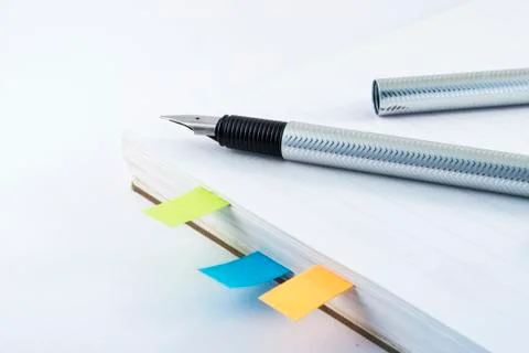 Fountain pen on white notebook with colorful stickers Stock Photos