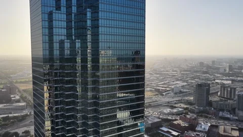 Fountain Place beyond a mirrored tower wall above hazy Dallas aerial drone view Vidéo 342502579
