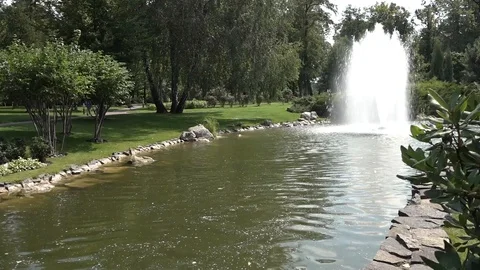 The fountain is set in the middle of a pond in a beautiful park. Video stock 100288951