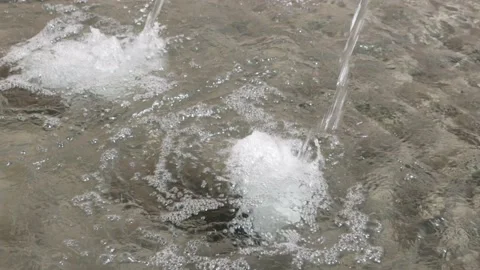 Fountain in slow motion, water flows extremely slowly into the basin, daytime Stock Footage 160275876