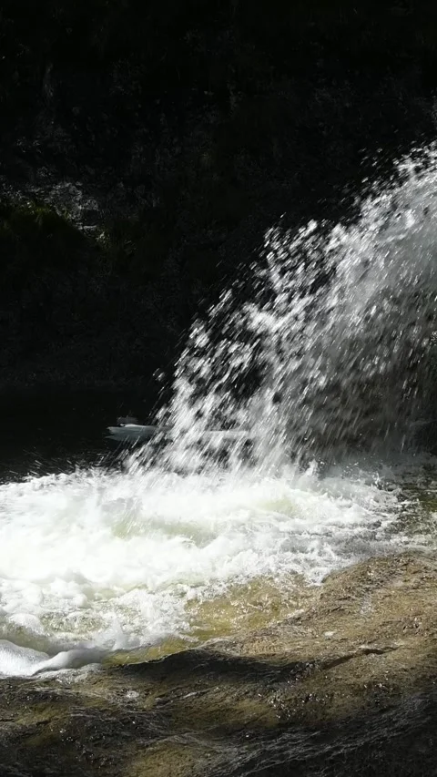 A fountain-like waterfall in direct sunlight, vertical shot, slow motion Stock Footage 260919748