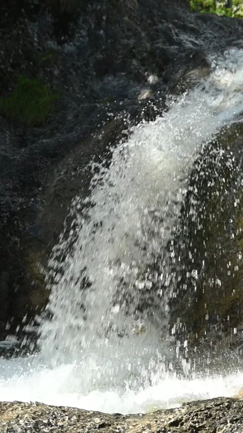 A fountain-like waterfall in direct sunlight, vertical shot, slow motion Stock Footage 260922347