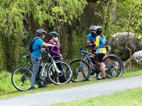 Four active cyclist at break stop at the park, Ecuador Stock Photos