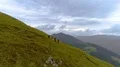 The four active people with backpacks walking down on a mountain 4k or 4k+ Resolution