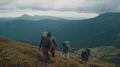 The four active people with backpacks walking up in the mountain 4k or 4k+ Resolution