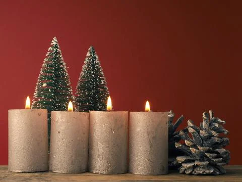 Four Advent candles burning on a red background Stock Photos