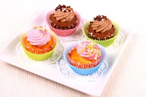 Four appetizing cupcakes on white plate Stock Photos