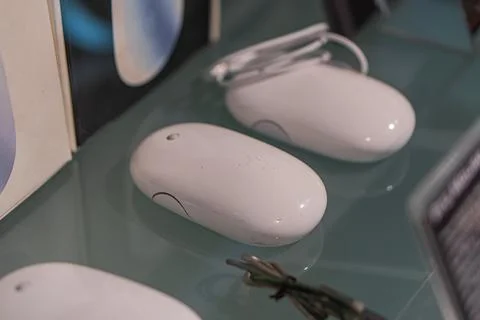 Four Apple computers mice arranged diagonally on a reflective surface, creati Stock Photos
