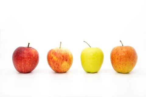 Four apples in a row with three red apples and one green apple Stock Photos