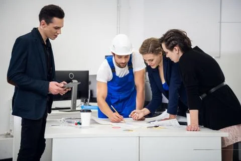 Four architects working on the project at the office Stock Photos