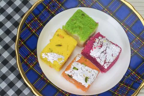 Four assorted barfi kept on a plate. Stock-Fotos
