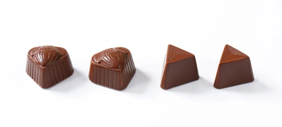 Four assorted chocolate truffles on table Stock Photos