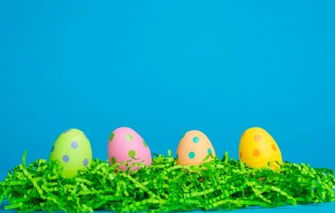 Four assorted color easter eggs on a sky blue background Stock Photos