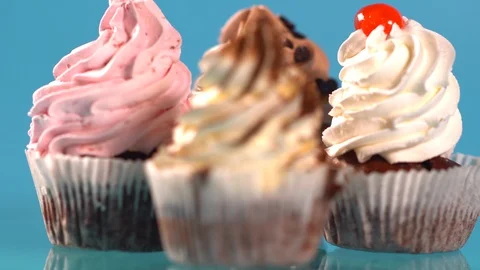 Four assorted cupcakes with twirled icing Video stock 96300431