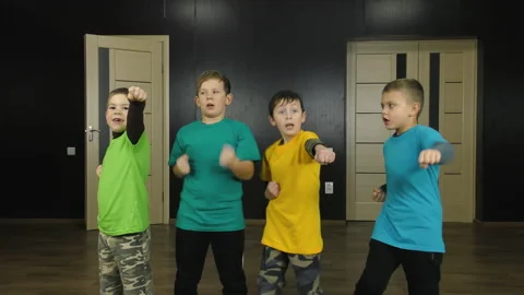 Four athletes in multi-colored T-shirts train punches Stock Footage 148097449