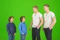 The four attractive brothers stand on the green background Photo