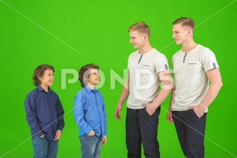 The four attractive brothers stand on the green background Stock Photos