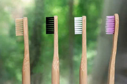 Four bamboo toothbrushes close-up on a background of nature. Foto stock