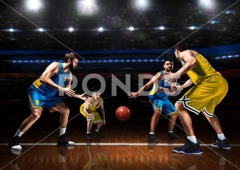 Four basketball players in game action on court Stock Photos