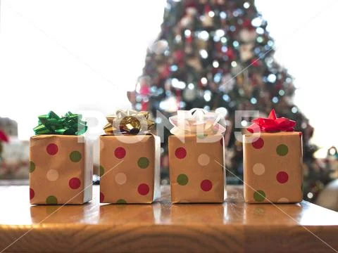 Four beautifully wrapped gift boxes on wood table. Stock Photos
