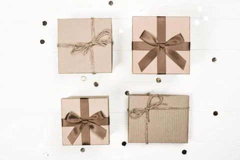 Four beautifully wrapped gift boxes with ribbons and natural twine decor Stock Photos