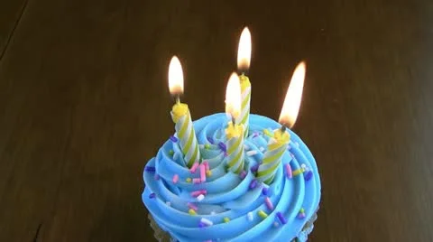 Four birthday candles on a cupcake Stock Footage