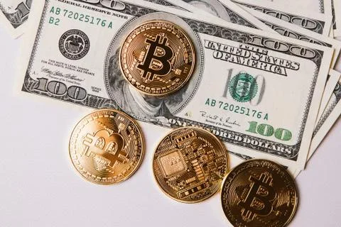 Four bitcoins and a bundle of dollars 库存照片