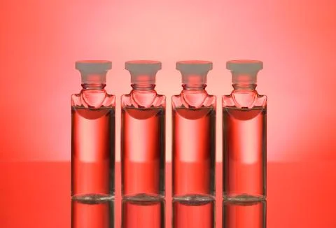 Four bottles back lit on red background Stock Photos