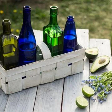 Four bottles of drinks in a white basket and fruits on the white table Stock-Fotos