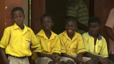 FOUR BOY STUDENTS WATCHING DRUMMERS AND DANCERS AT SCHOOL CEREMONY Stock Footage 59865624