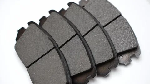 Four brake pads on white background rotate on turntable. Auto parts replacement Stock Footage 323055788