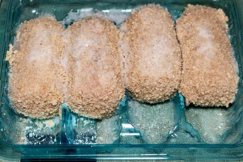 Four breaded chicken nuggets in plastic container ready to cook delicious meat 写真素材