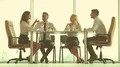 The four business people sit at the office table near the panoramic window HD Footage
