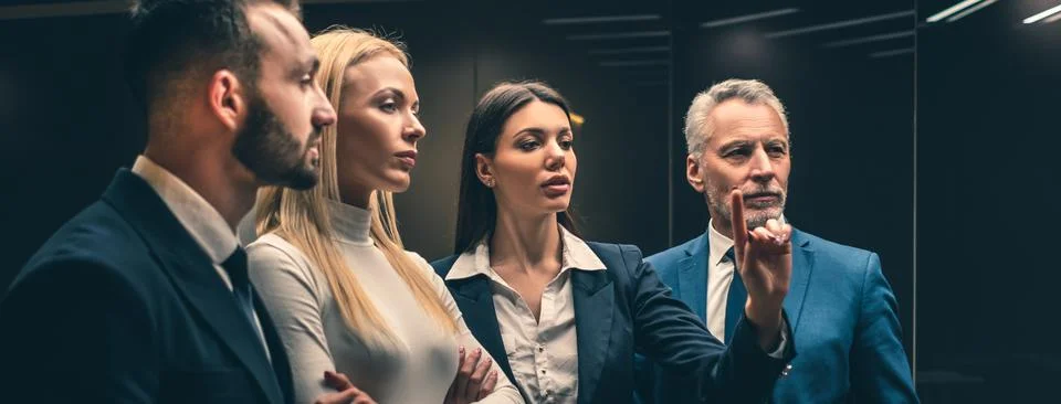 The four business people standing indoor Stock Photos