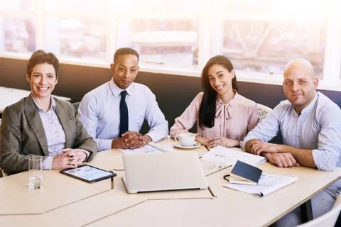Four business professionals looking at the camera during a meeting Stock Photos