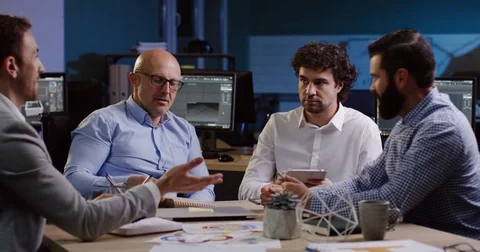 Four businessmen sitting at the table and discussing their future plans, than Stock Footage 82473645