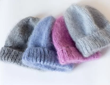 Four caps of different colors connected by hand from mohair Foto stock