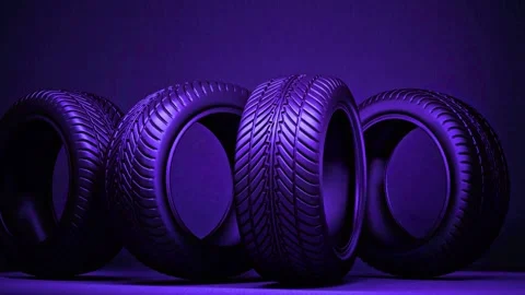 Four car tires rotating slowly in cool purple light on a dark studio backdrop Stock-Footage 342905705