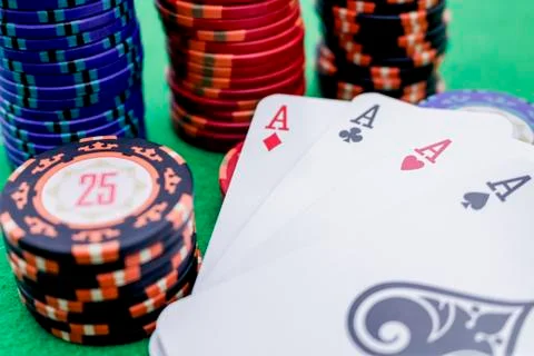 Four cards with aces next to a stack of poker chips Stock Photos