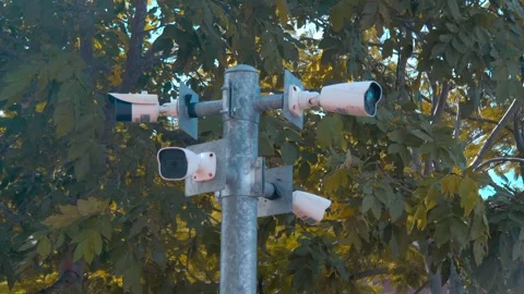 Four CCTV cameras are positioned high on a metal pole, providing full 360-degree Stock Footage 308863247